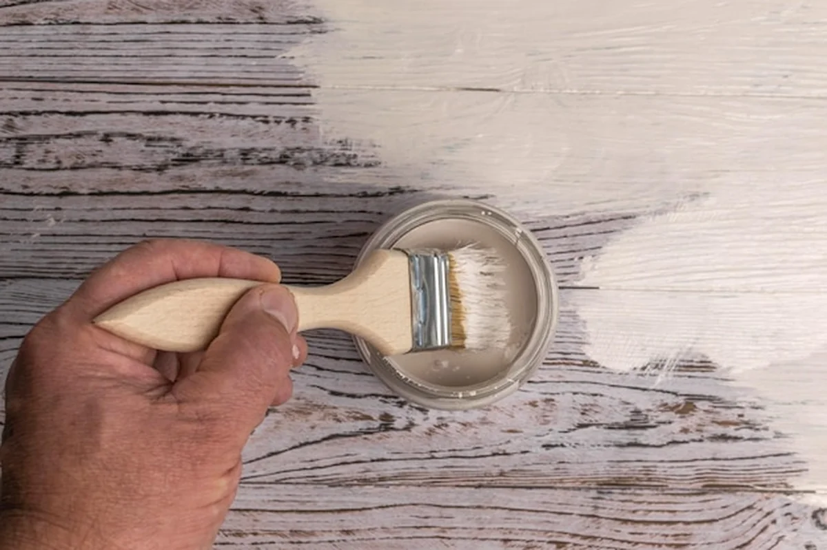 Malowanie drewnianej powierzchni białą farbą szczotką