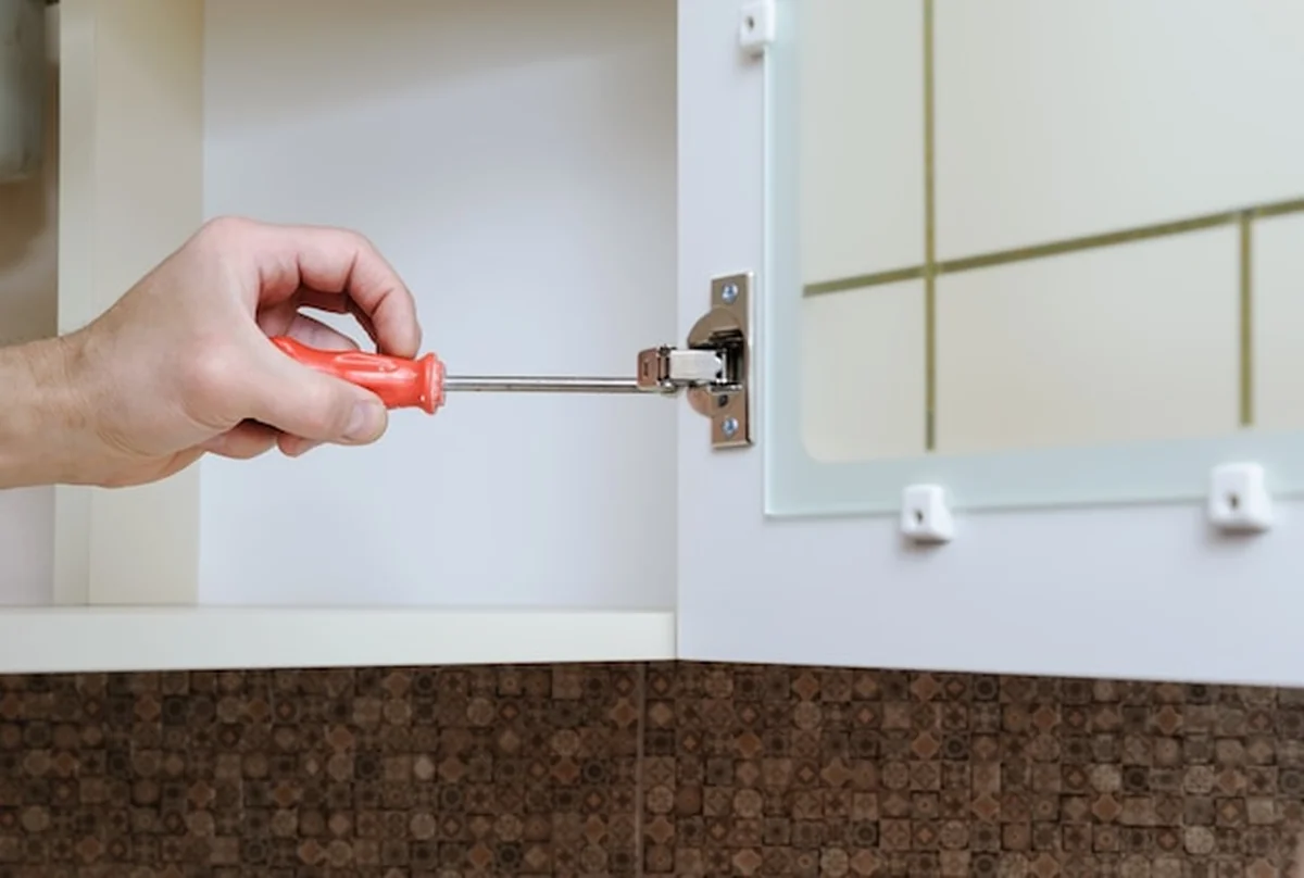 Montaż mebli kuchennych śrubokrętem do drzwi szafki