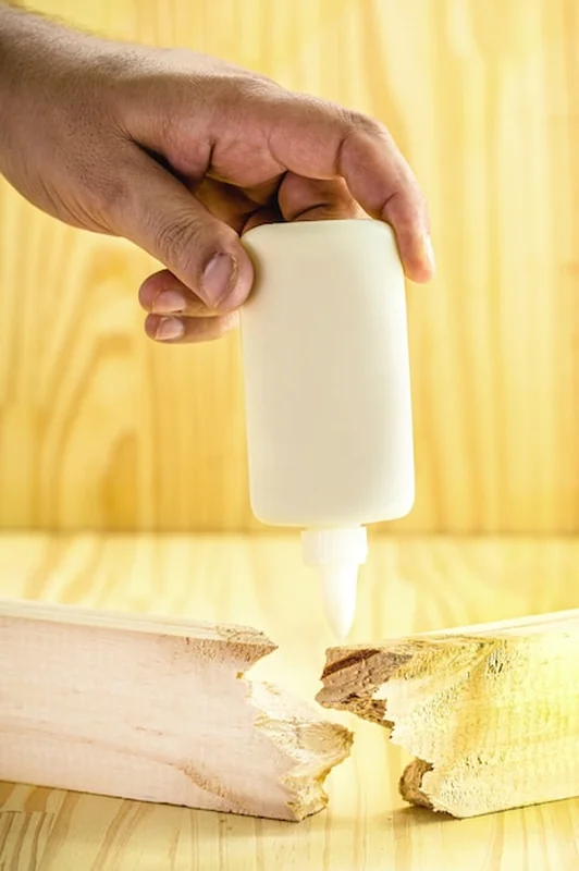 Stolarz nakładający klej do drewna na deskę