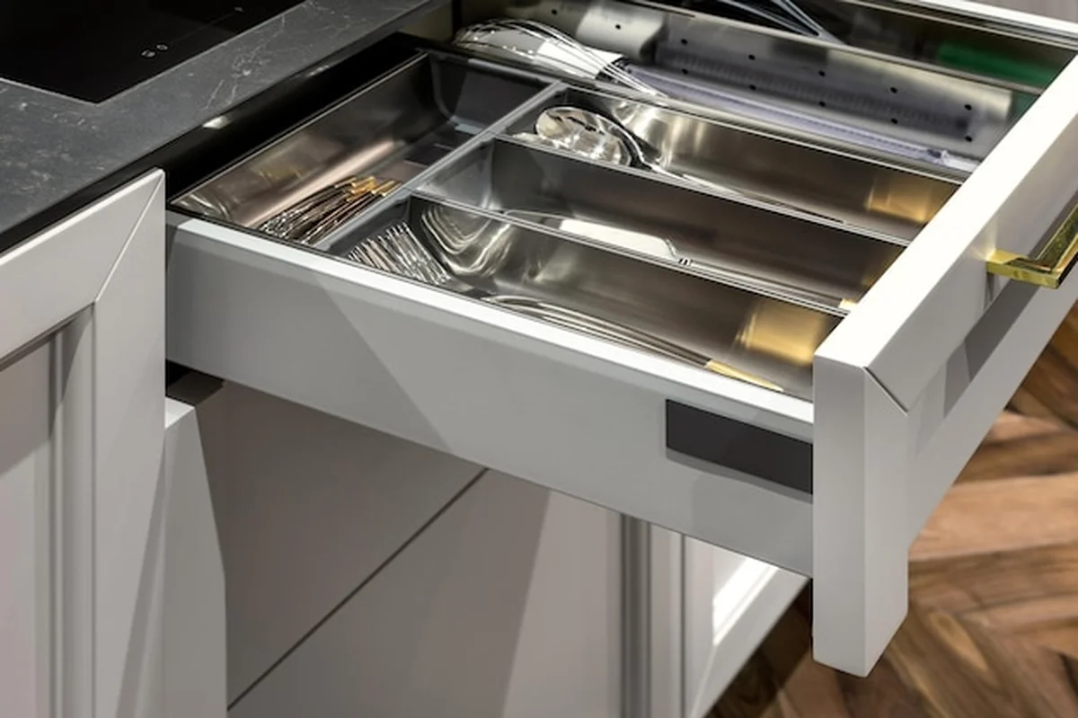 Metalowy organizator szuflad kuchennych w drewnianej kuchni z narzędziami kuchennymi