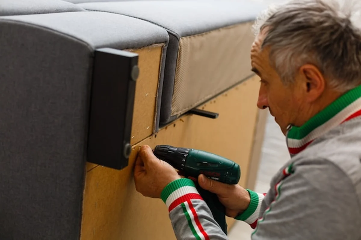 Mężczyzna naprawia sofę