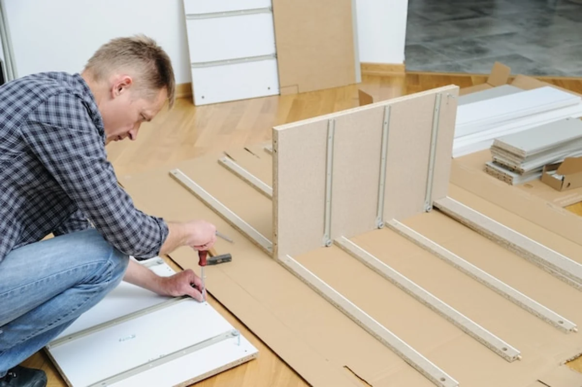 Mężczyzna instalujący śruby w płycie meblowej