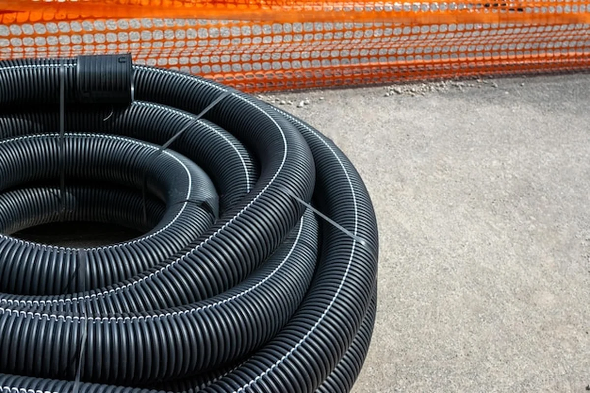 Długie plastikowe rury na placu budowy pod systemy elektryczne