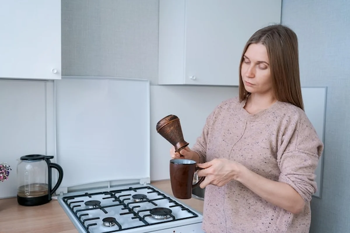 Kobieta robi kawę w kuchni