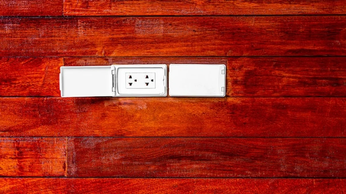 Nowoczesna nasadka elektryczna przy drewnianej ścianie