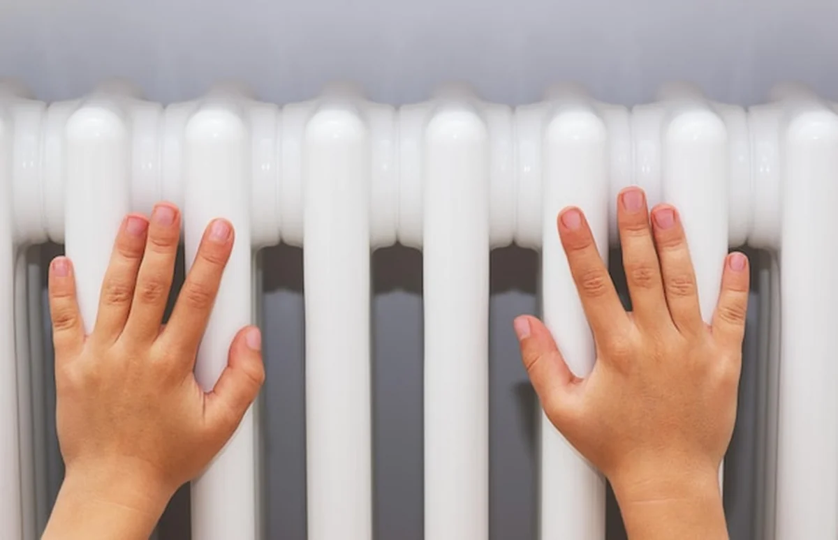 Ręce dzieci na grzejniku w bloku
